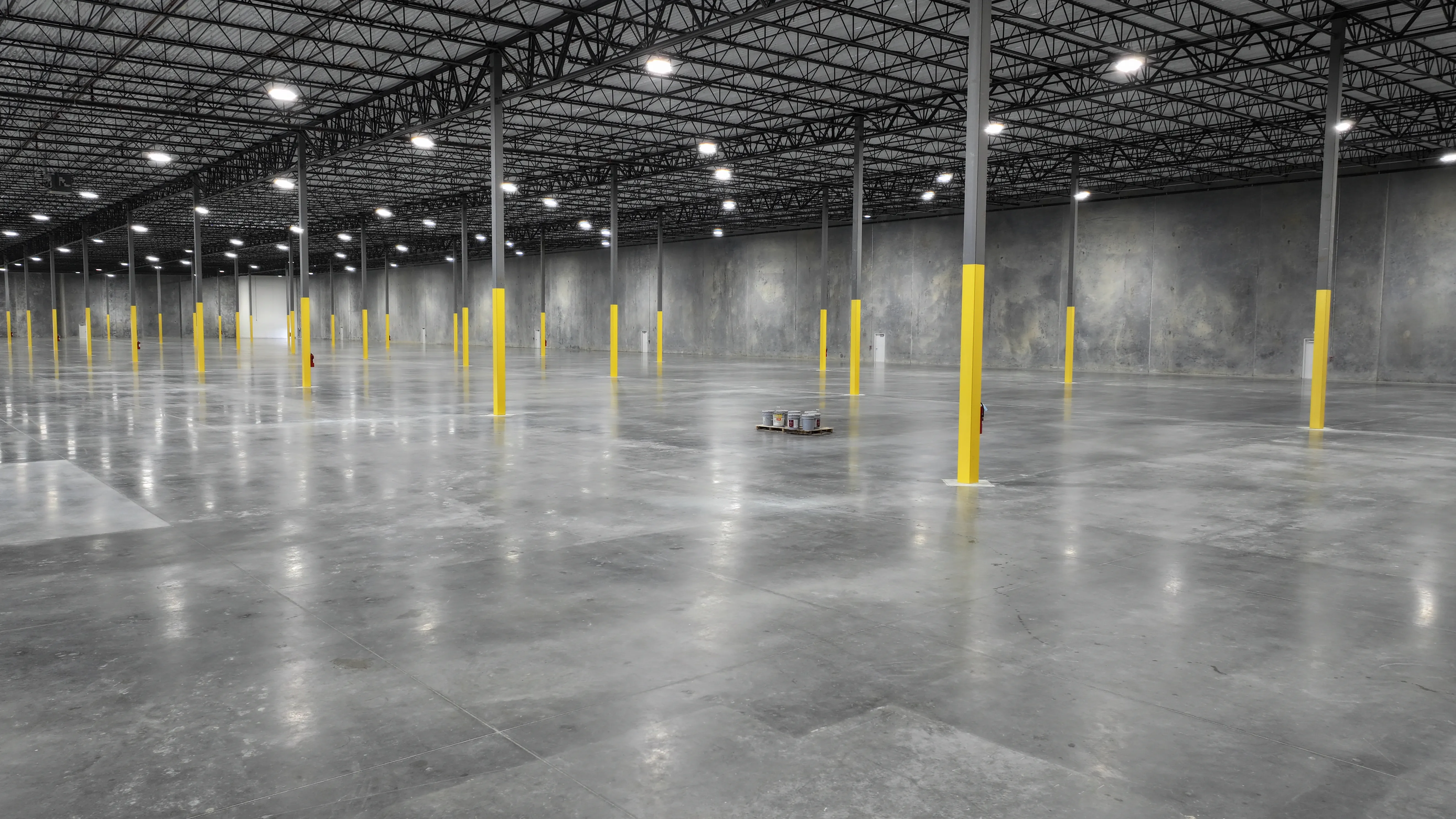 Interior view of steel roof framing and a concrete floor at Pasadena Logistics Center
