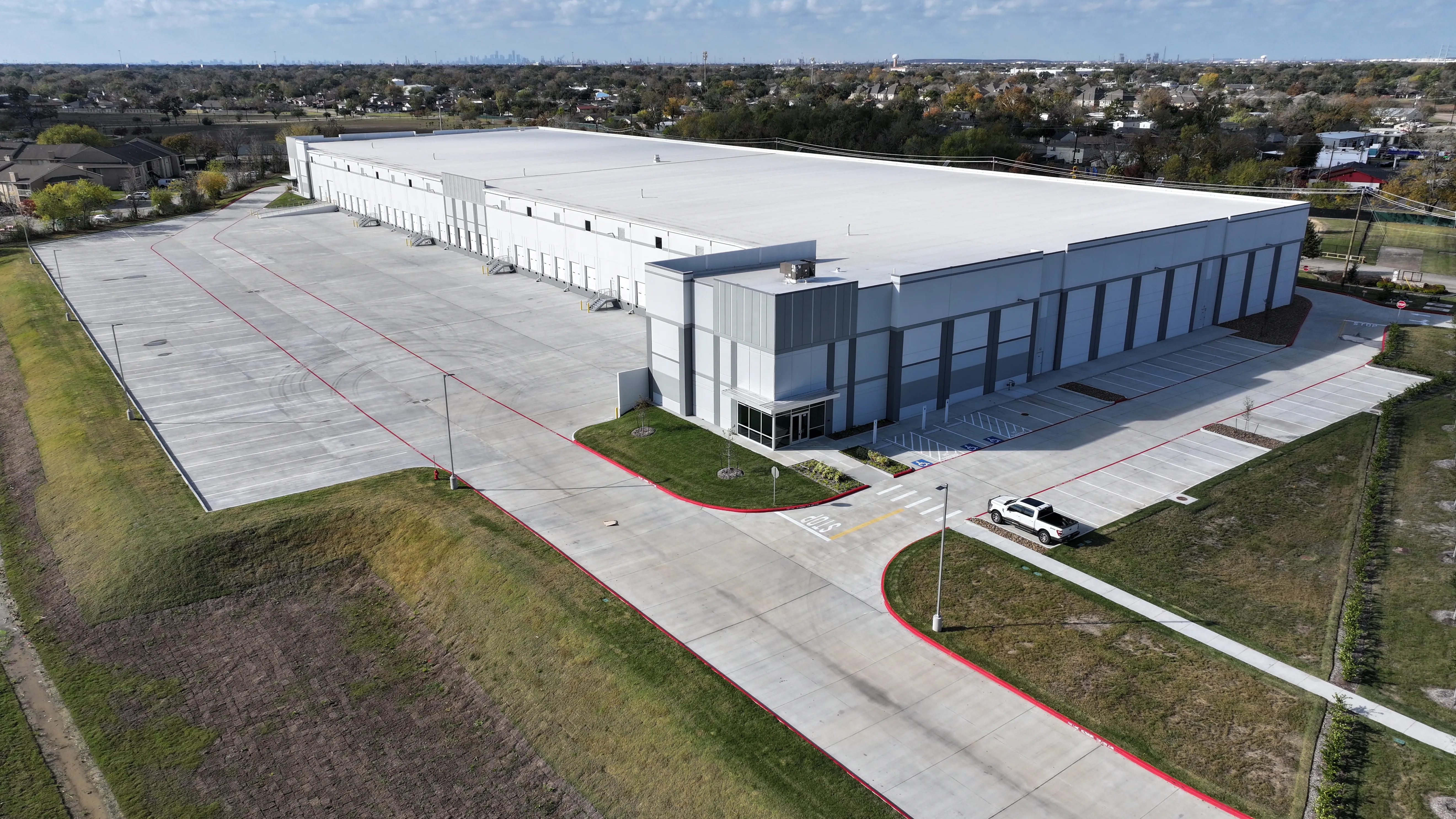 Aerial exterior view of a long white warehouse at Pasadena Logistics Center