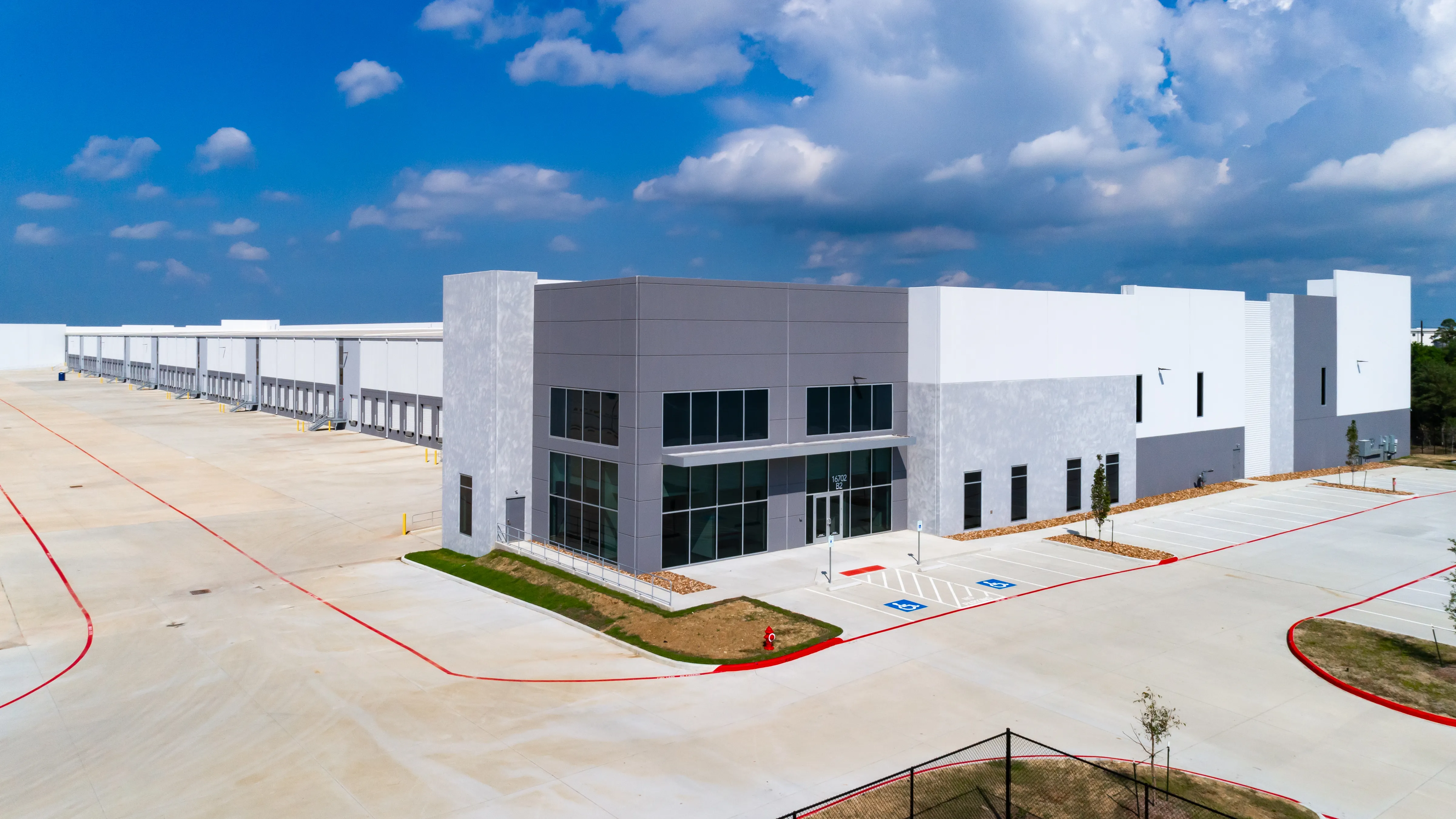 Aerial view of a white building with a dark glass entrance at Port 99